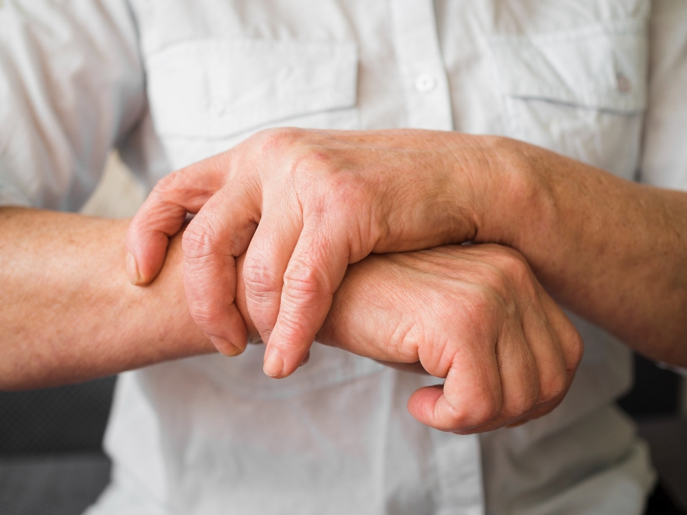Close-up of one hand holding the other wrist, a visual for joint protection techniques